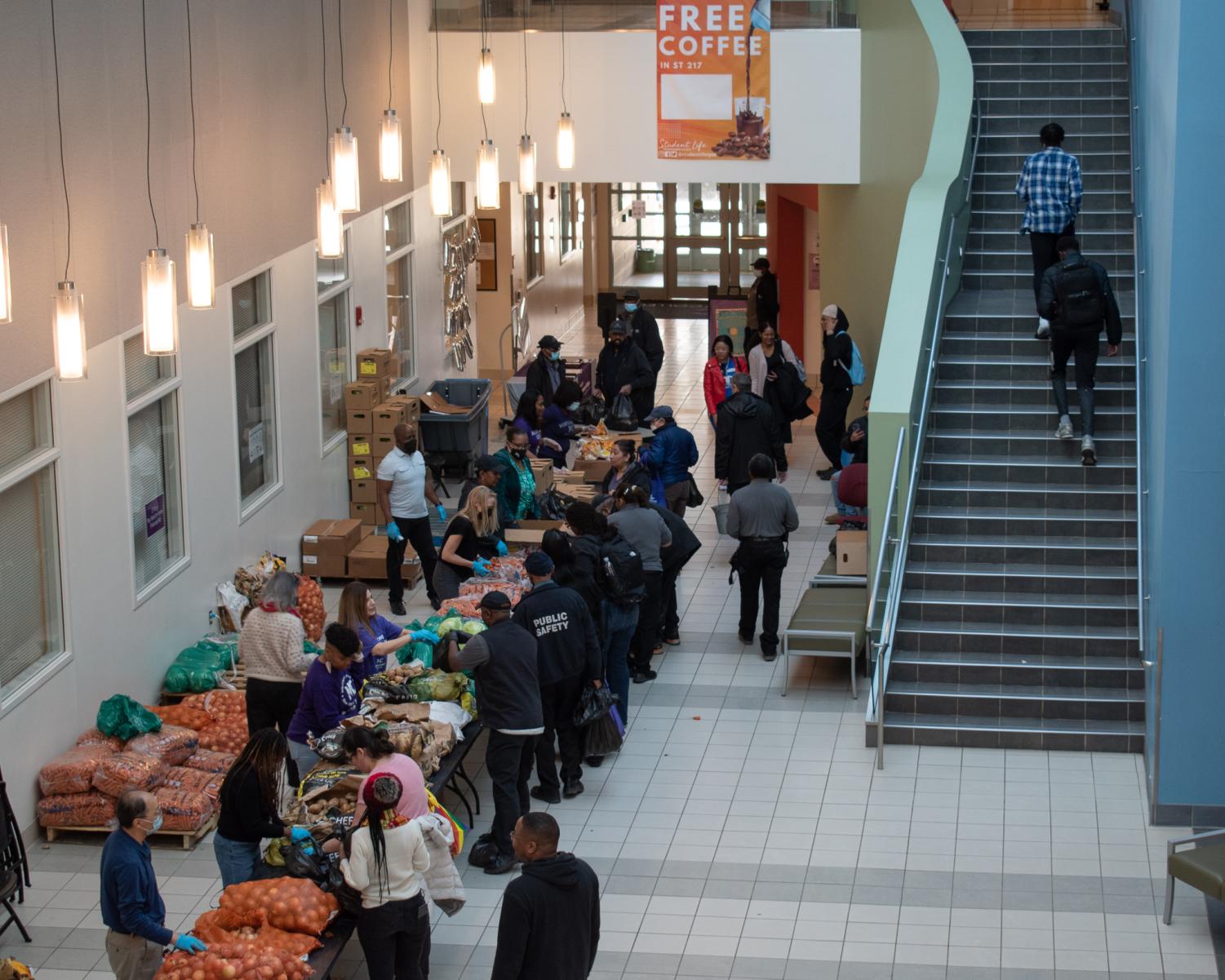 Students gather in the ST atrium to receive bags of free food. Students and faculty volunteer to serve fellow members of the MC community. over 5,000 lbs of food were donated at the mobile market.