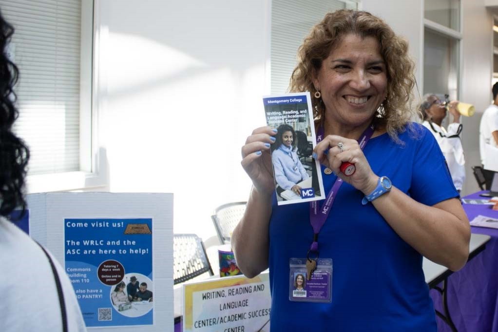 Thamar Gonzalez-Kaufman, Instructional Associate of the Academic Success Center and the Writing, Reading, and Language Center poses with a pamphlet.