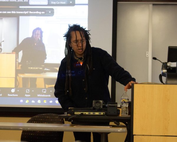 The poet Taylor Johnson speaks to an audience of college students and faculty at an afternoon speakers event and reflects on his life story. 