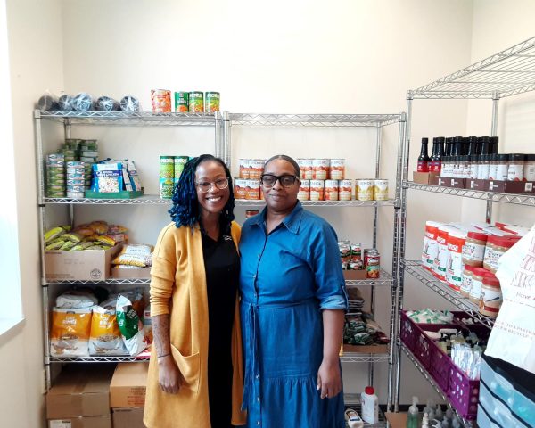 Demetra Crawford, Director of Student Life, left, standing with Mia Price, Student Life Specialist, right, in the Thrive Pantry storage room in the Student Life Office on the Takoma Park campus, which provides hygiene products and food for students.