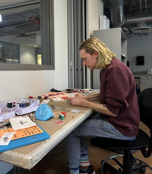 Lucas J Rougeux works on their latest piece in their studio, using fabric and bead mediums along with embroidery and quilting techniques.