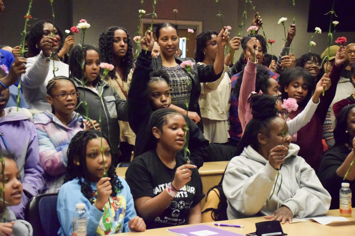 Attendees raise carnations during the conclusion of the morning session at the March 22 STEMpowHER Conference in the HC Building. According to Every Girl Can founder Yasmin Anderson-Smith, the “Yes! I Can” carnations rising is a traditional rite at each Every Girl Can conference, symbolizing a shared dedication to STEM and its broader impact.