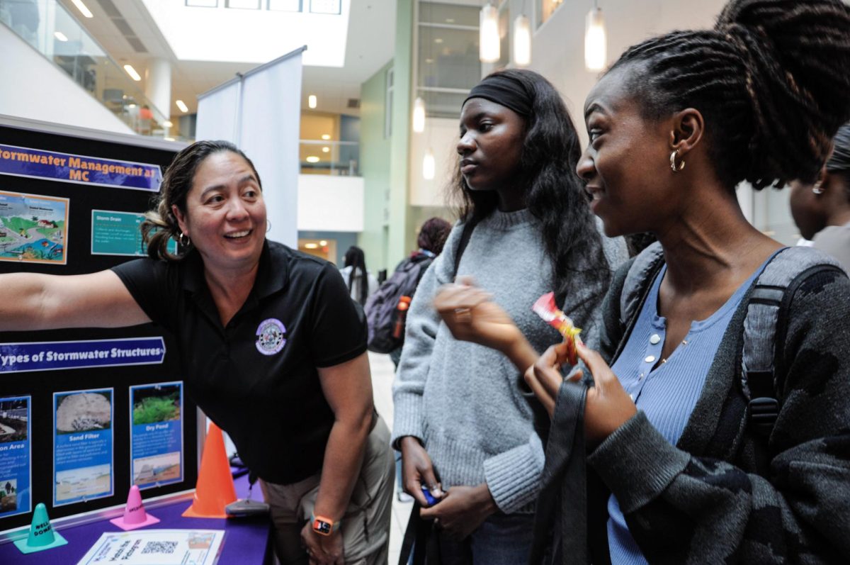 Environmental safety manager Mai Toyofuku, left, shares information on stormwater management with computer science major Anais Sitamdze, center, and biochemistry major Khadijatu Fofanah, right, during the Sept. 11 Campus Safety Fair in the ST Atrium.